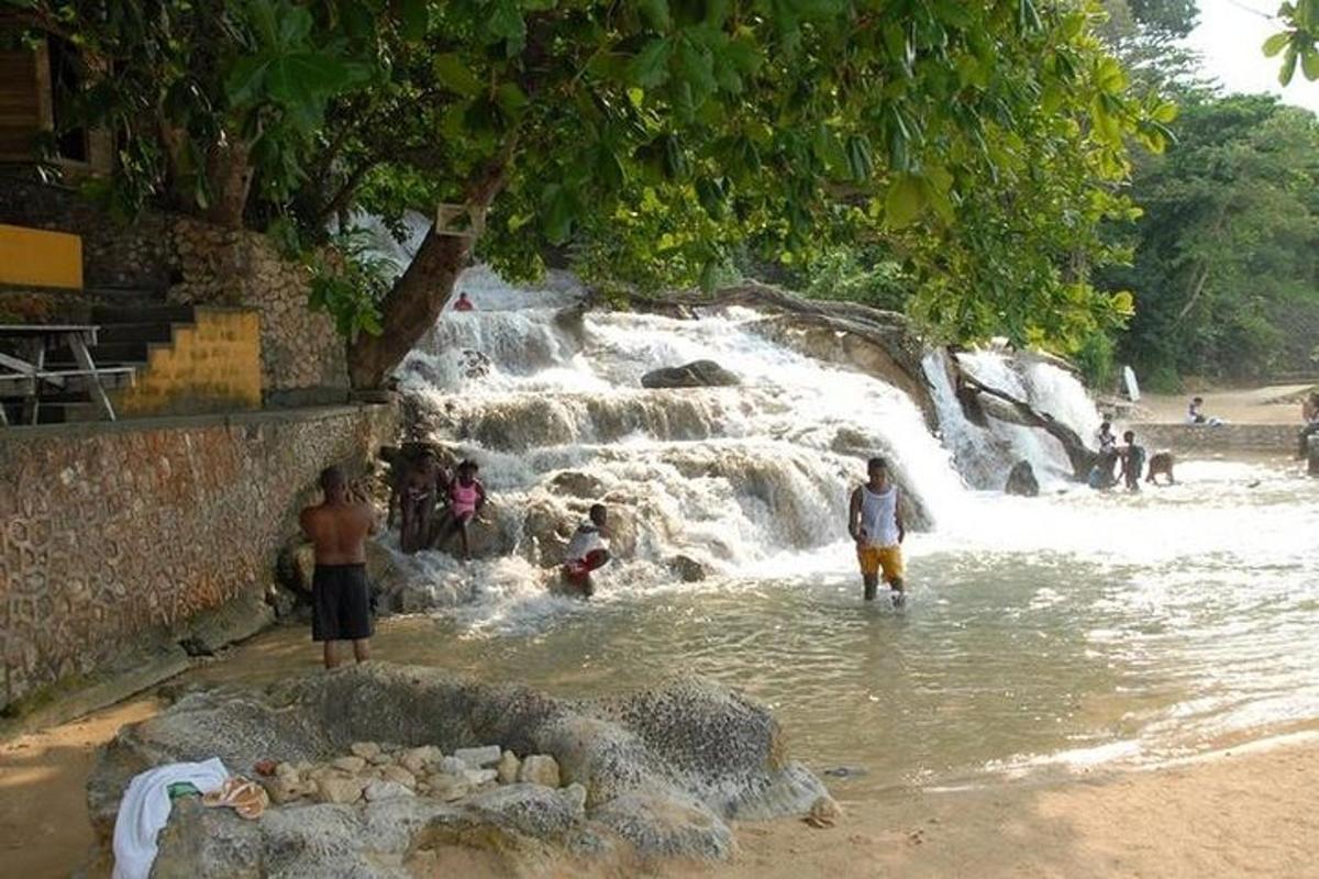un gruppo di persone in piedi nell'acqua vicino a una cascata