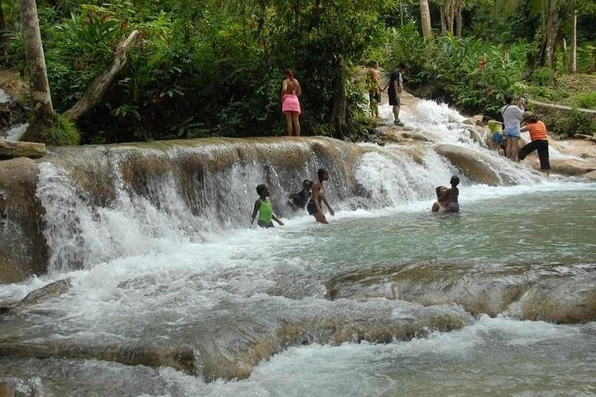 un gruppo di persone in piedi nell'acqua di una cascata