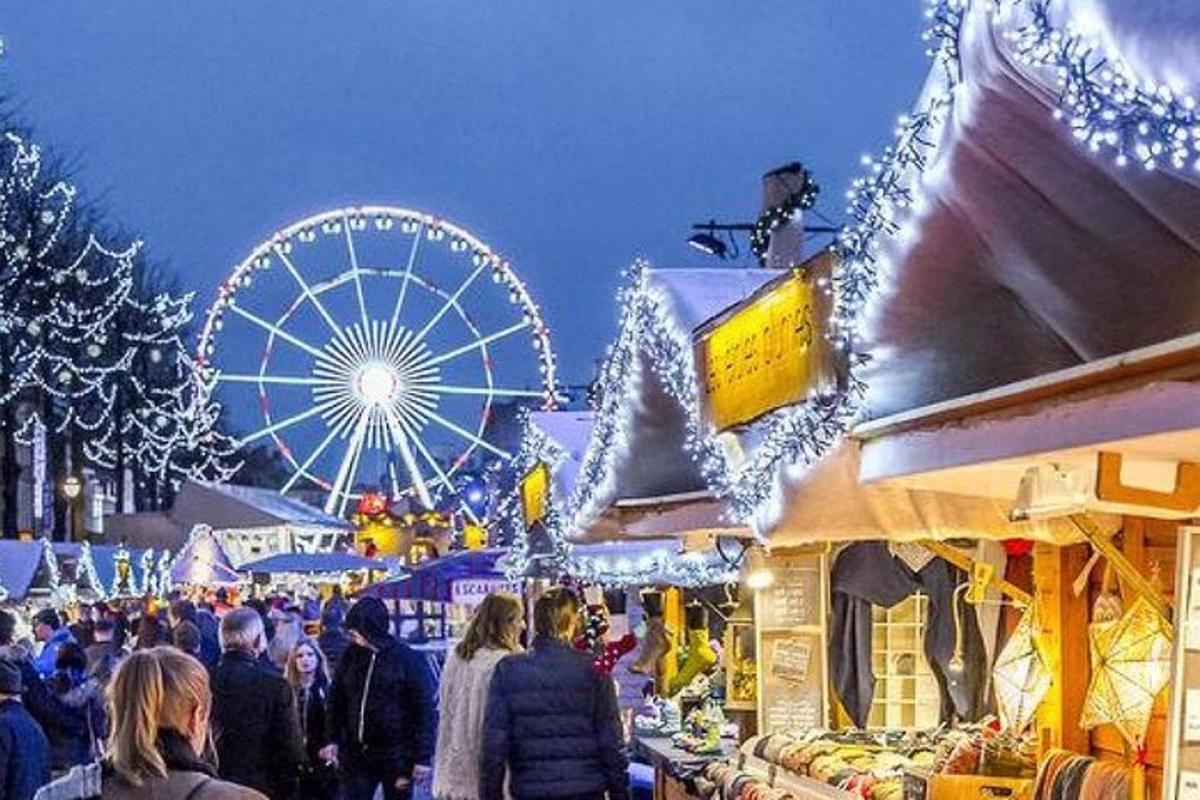 en julmarknad med ett pariserhjul och en folkmassa
