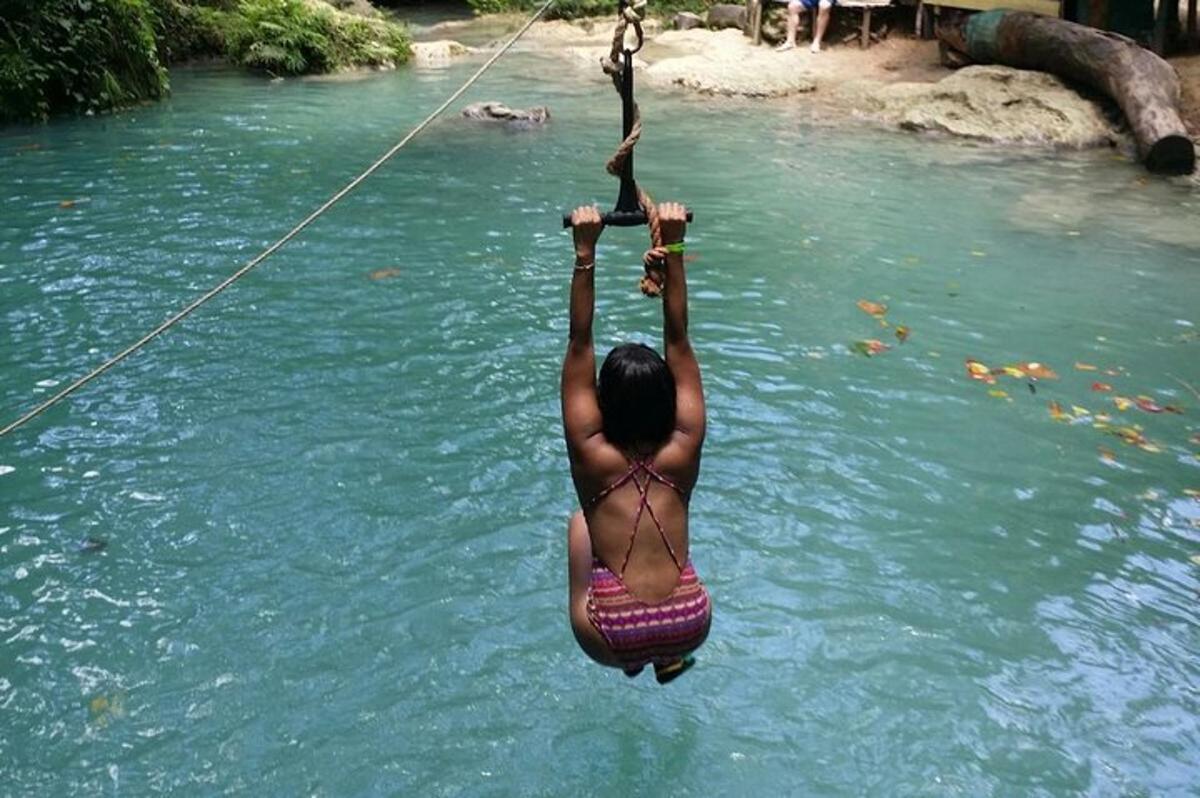 a person in the water on a rope in a river
