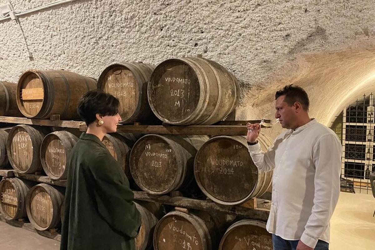 muž a žena stojící před hromadou sudů