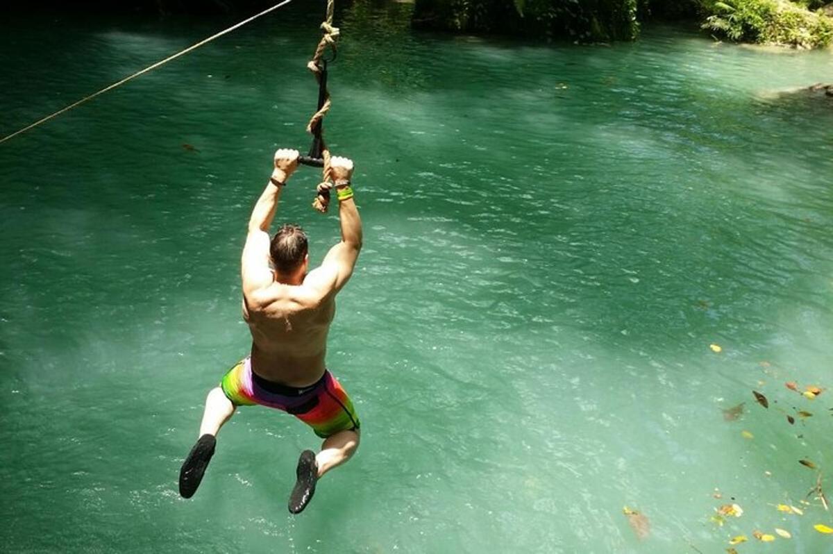 a man hanging from a rope in the water