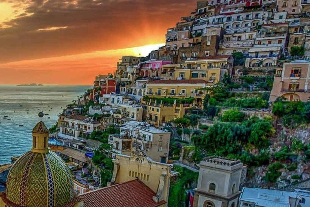 a group of buildings on a hill next to the ocean