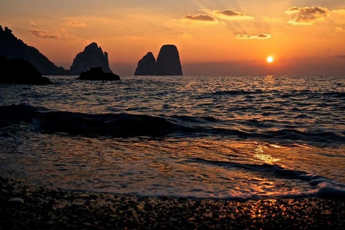 ein Sonnenuntergang am Strand mit Felsen im Wasser