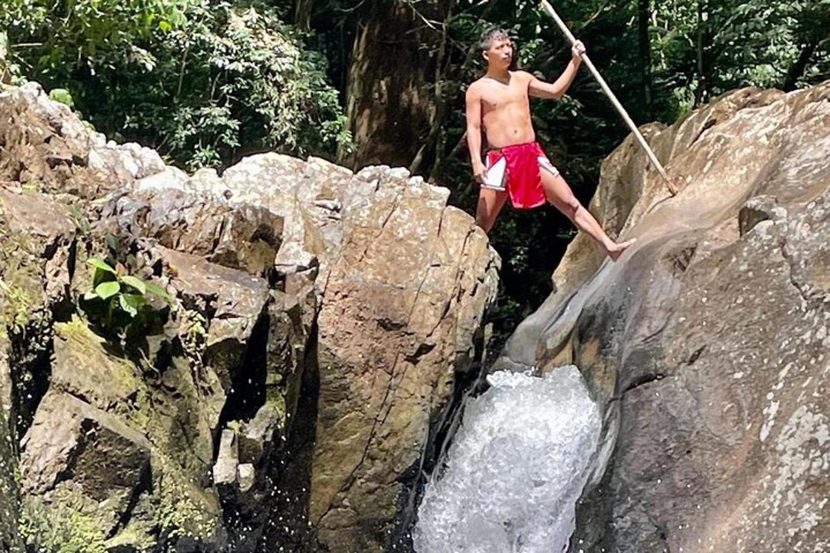 un uomo in piedi su una roccia con un bastone