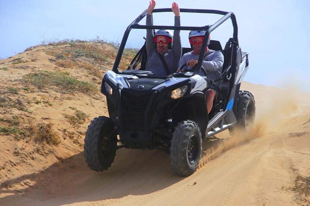 two men riding in a jeep on a dirt road