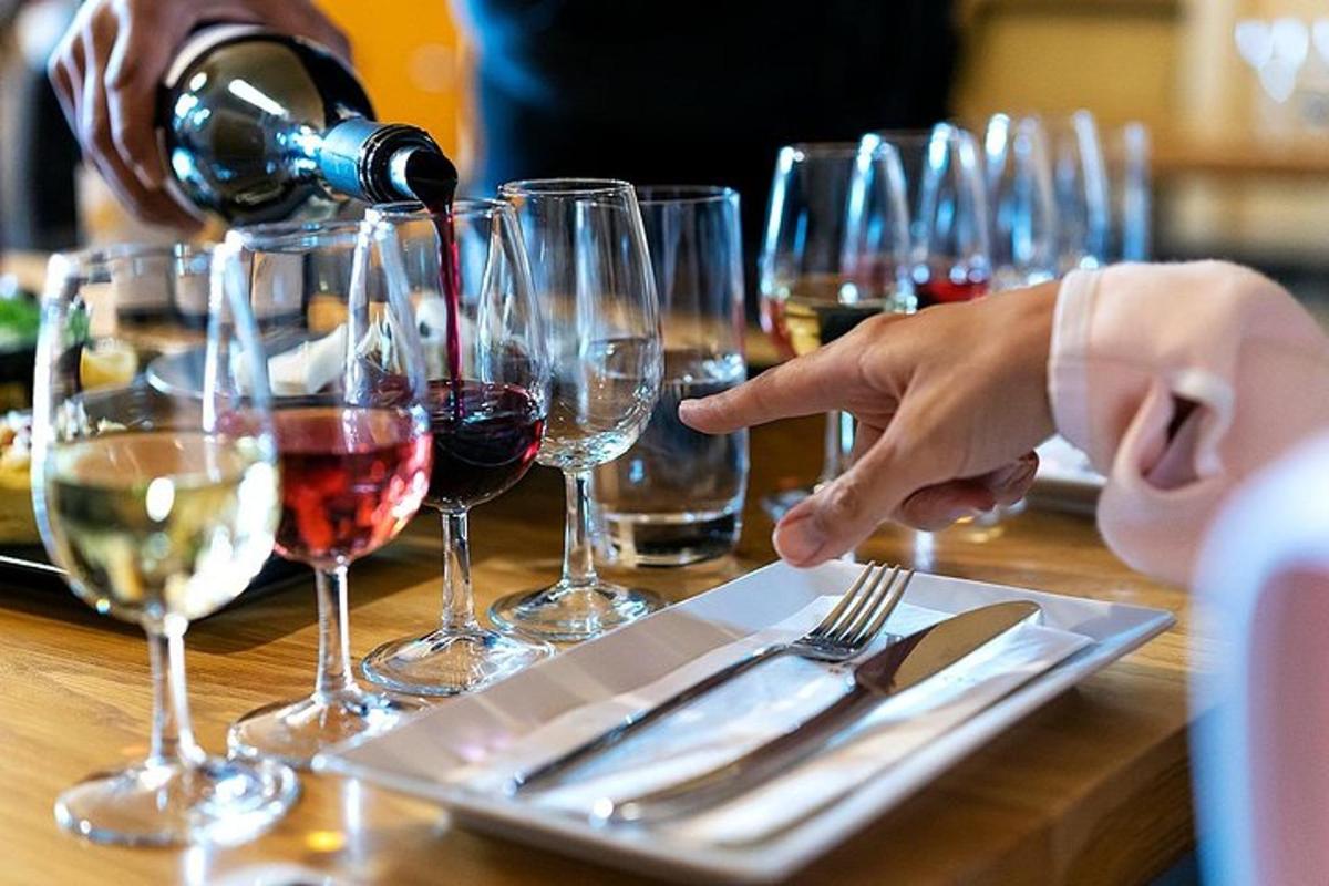 oseba, ki naliva vino v krožnik z vinskim kozarcem