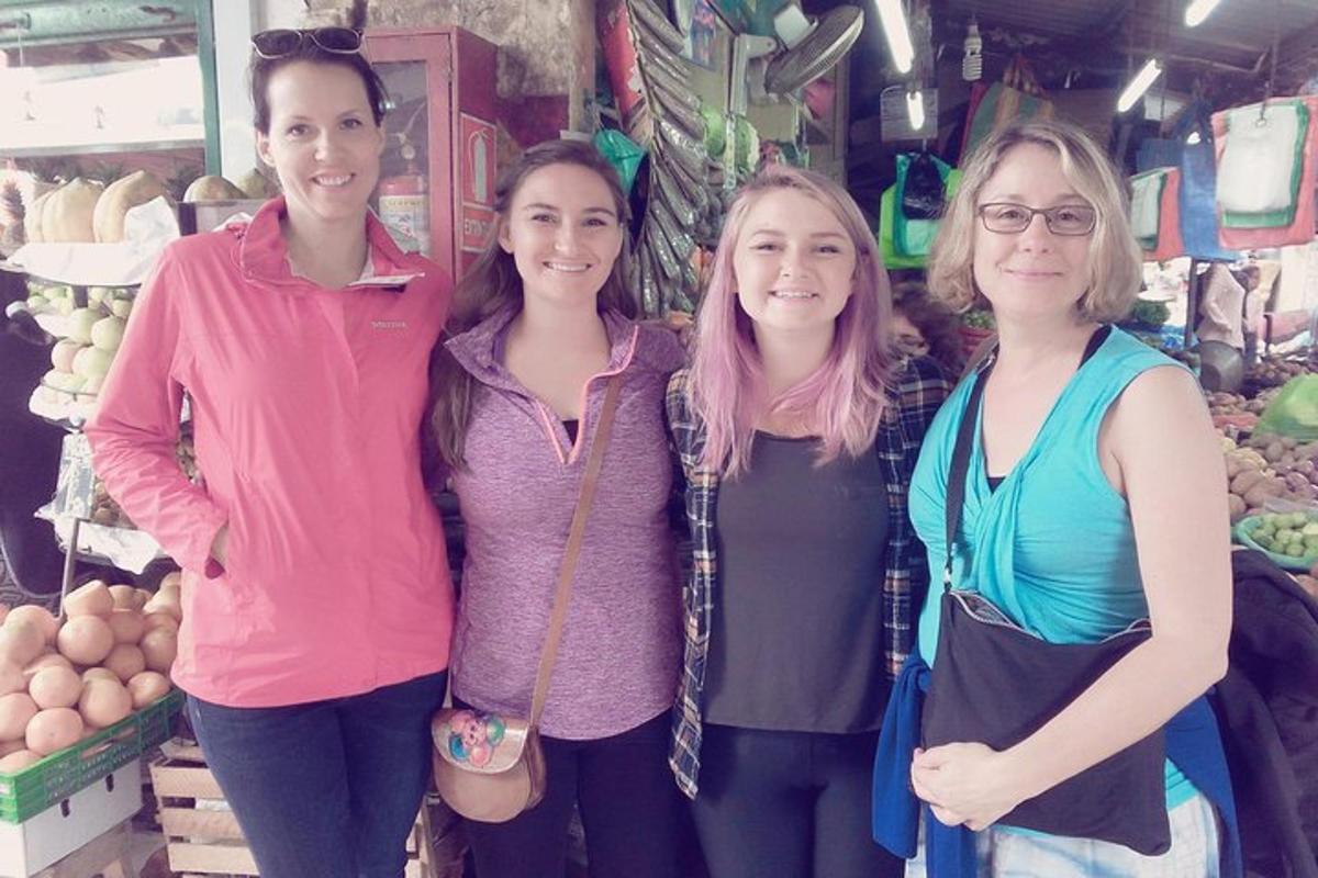 Un grupo de tres mujeres de pie en un mercado.