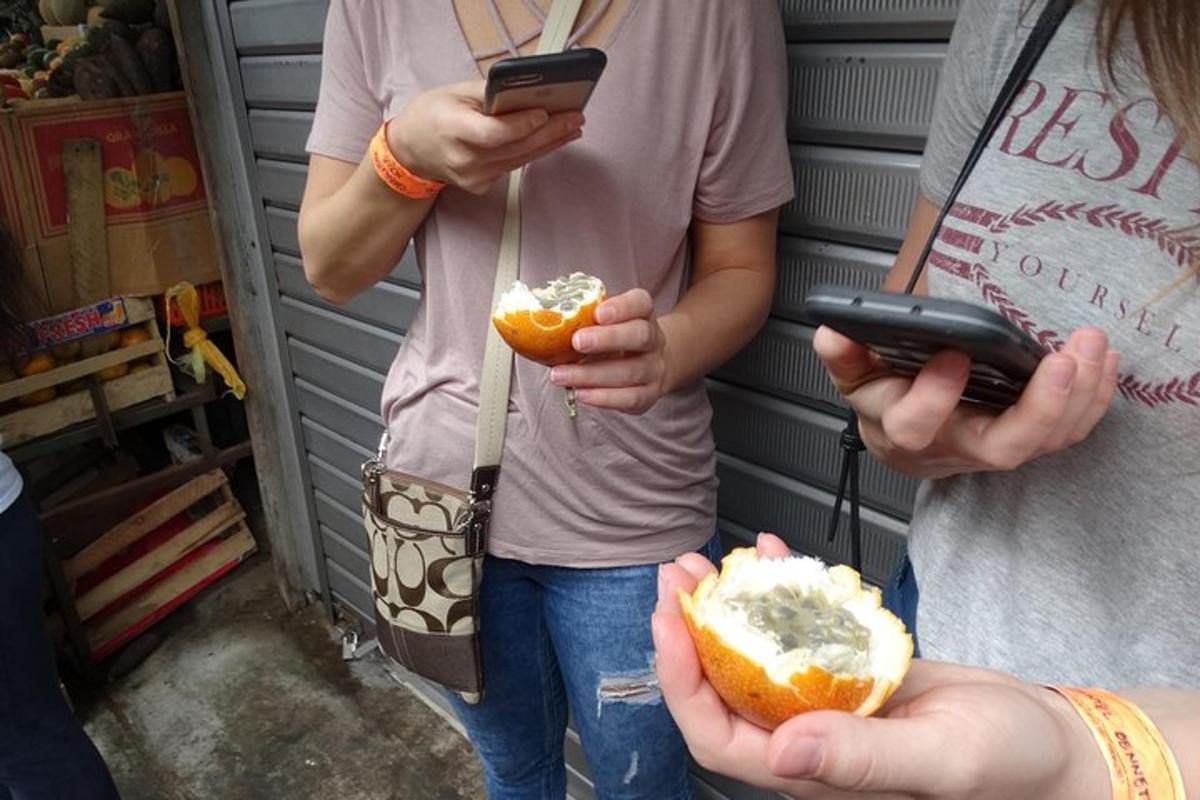 kaks inimest hoiavad käes mobiiltelefone ja hot dogi
