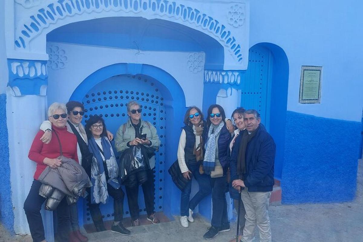um grupo de pessoas em pé em frente a uma porta azul