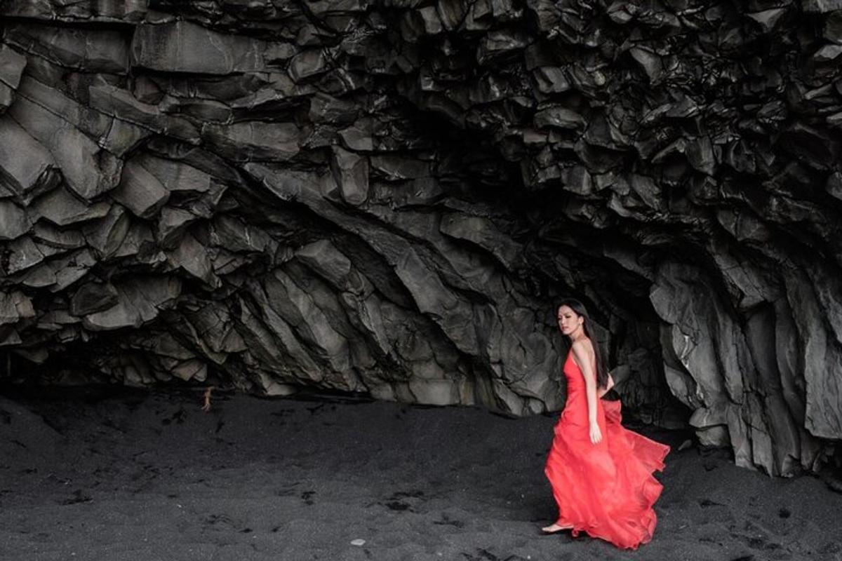 uma mulher de vestido vermelho caminhando por uma caverna