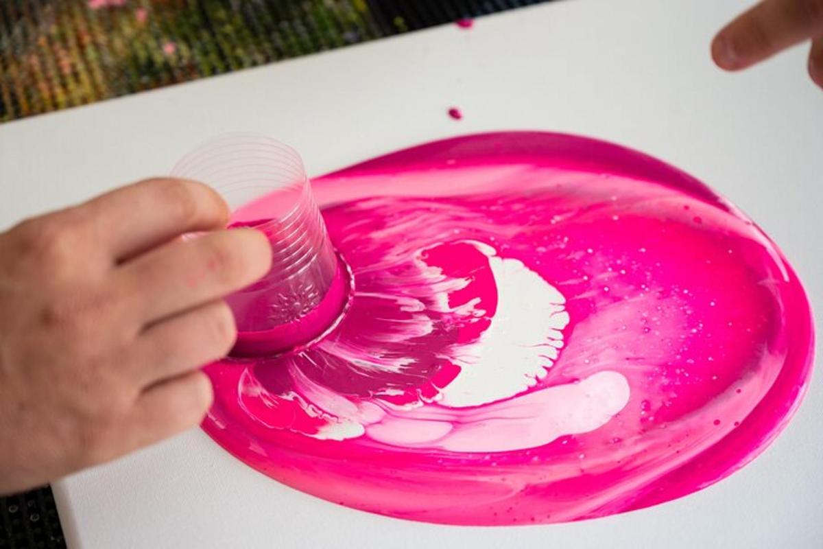 uma pessoa segurando uma pintura rosa com um pincel
