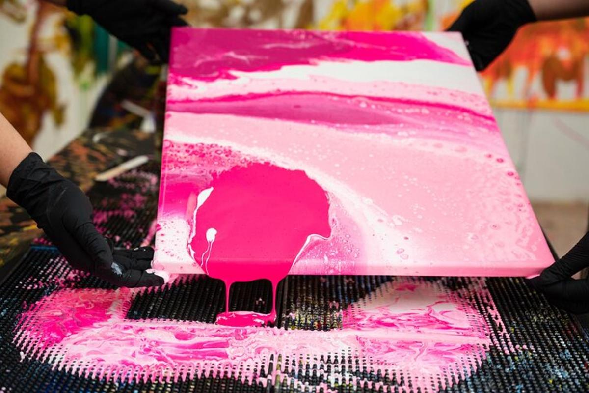 una persona que sosté un pastís rosa i blanc