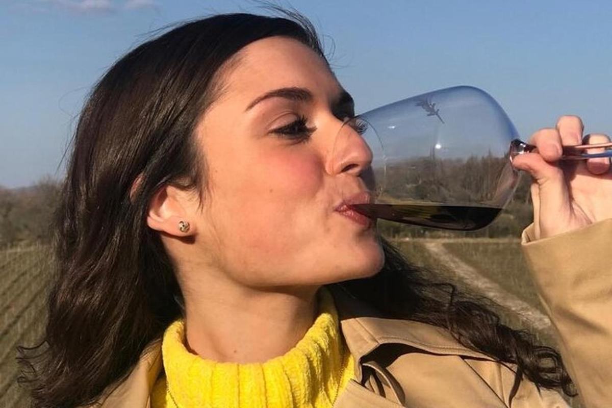 een vrouw die een glas rode wijn drinkt