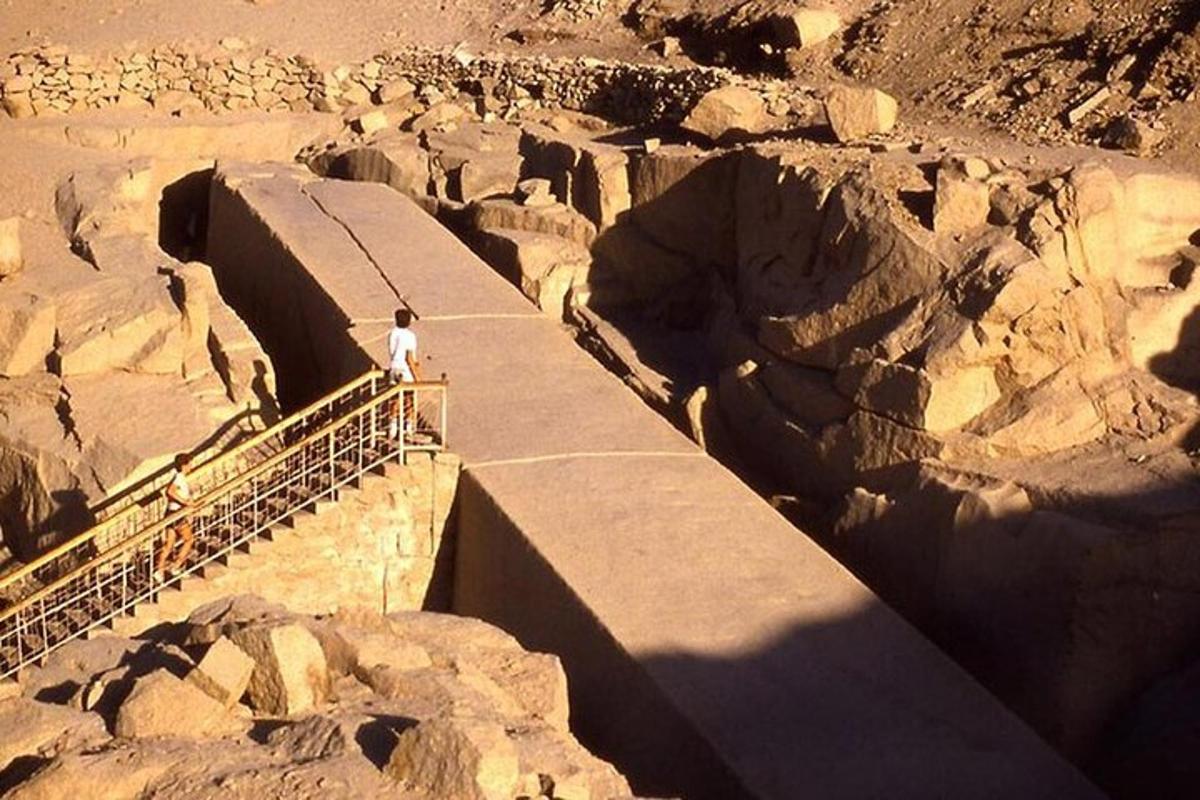 Un hombre parado en un puente sobre una montaña rocosa