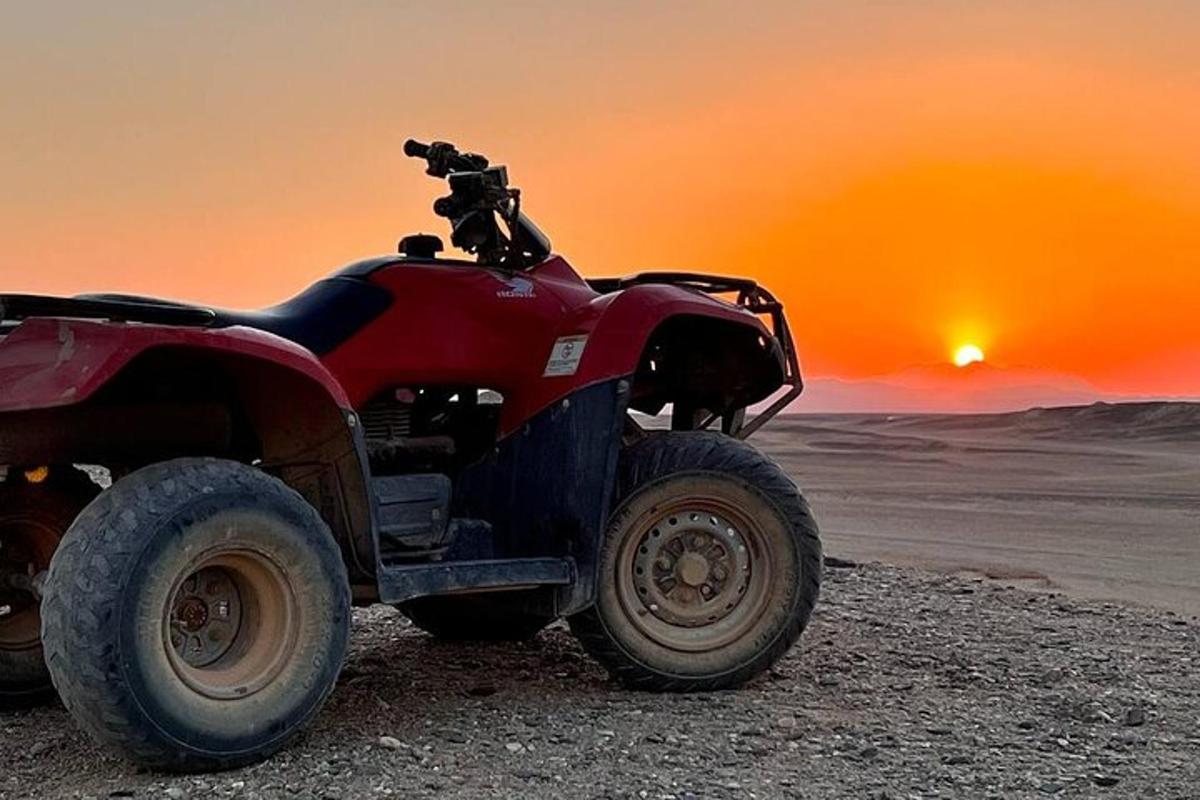 päikeseloojangul kõrbes pargitud punane ATV