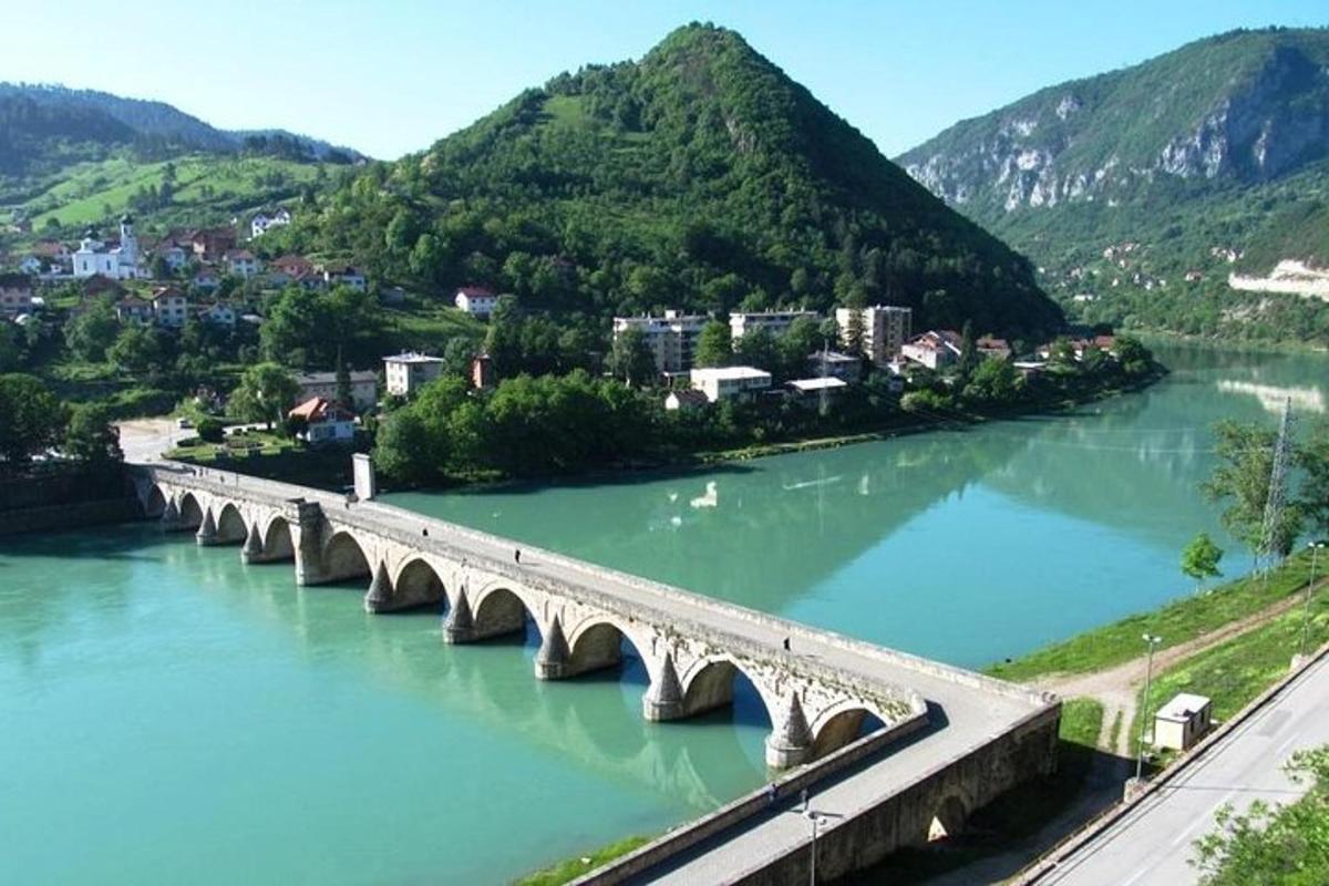 un ponte sopra un fiume con le montagne sullo sfondo