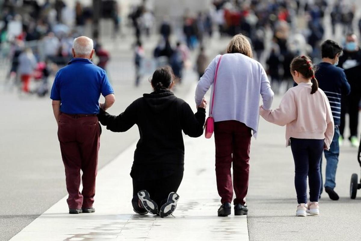 un gruppo di persone che camminano lungo una strada tenendosi per mano