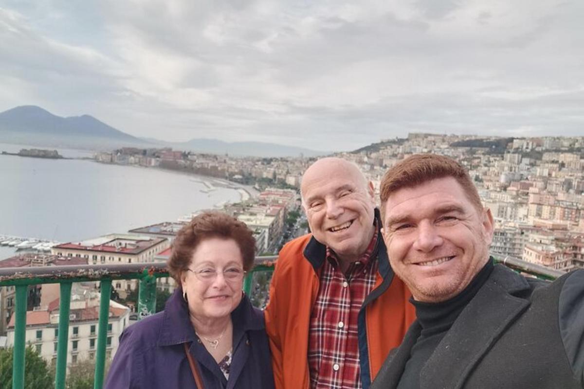 skupina tří lidí stojící na vrcholu města