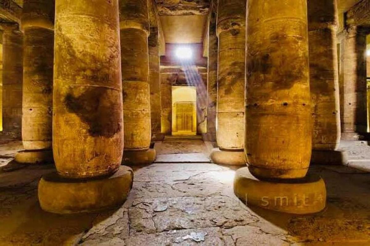 Una fila de columnas en un edificio antiguo con una luz