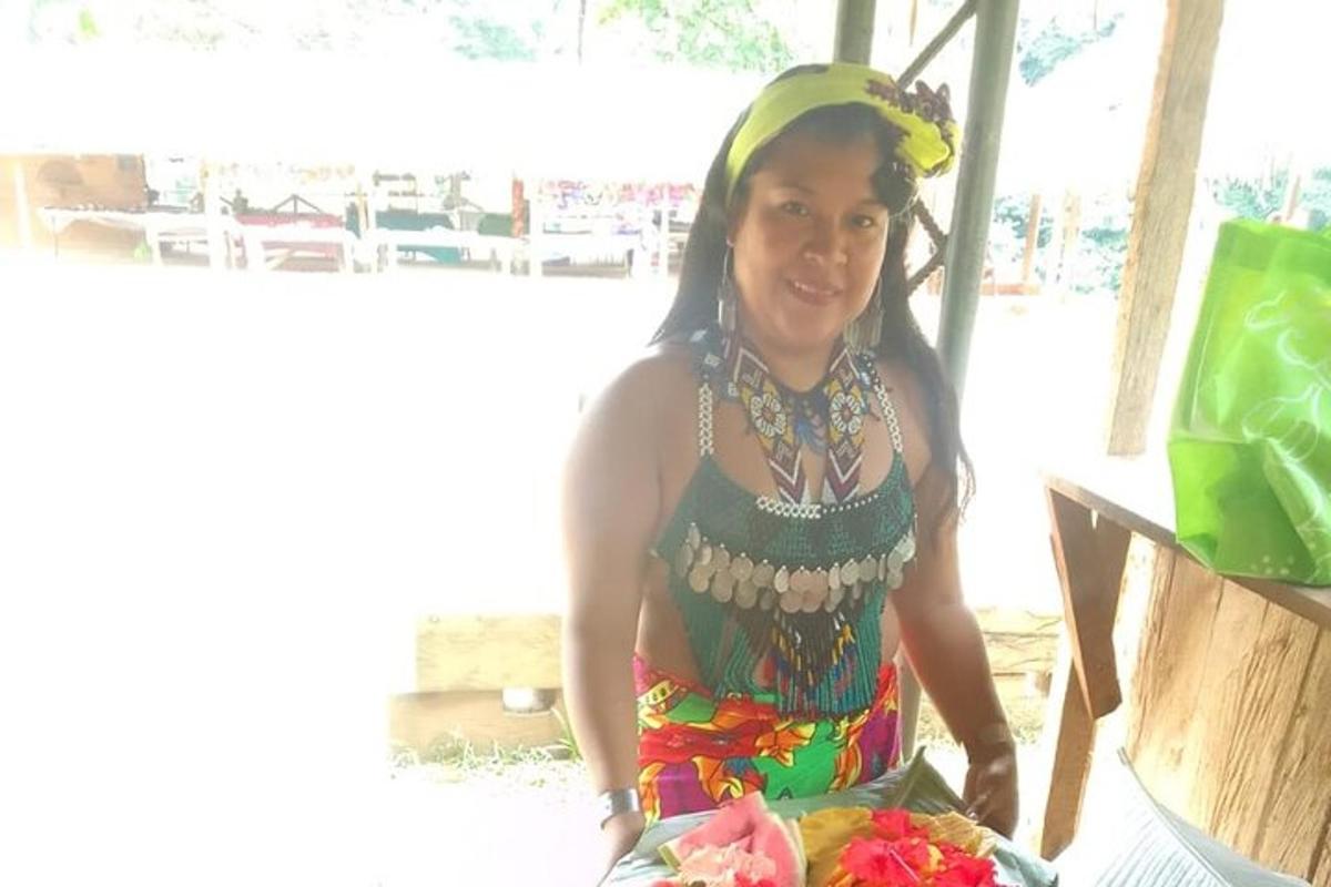 Una mujer está de pie con un plato de comida.