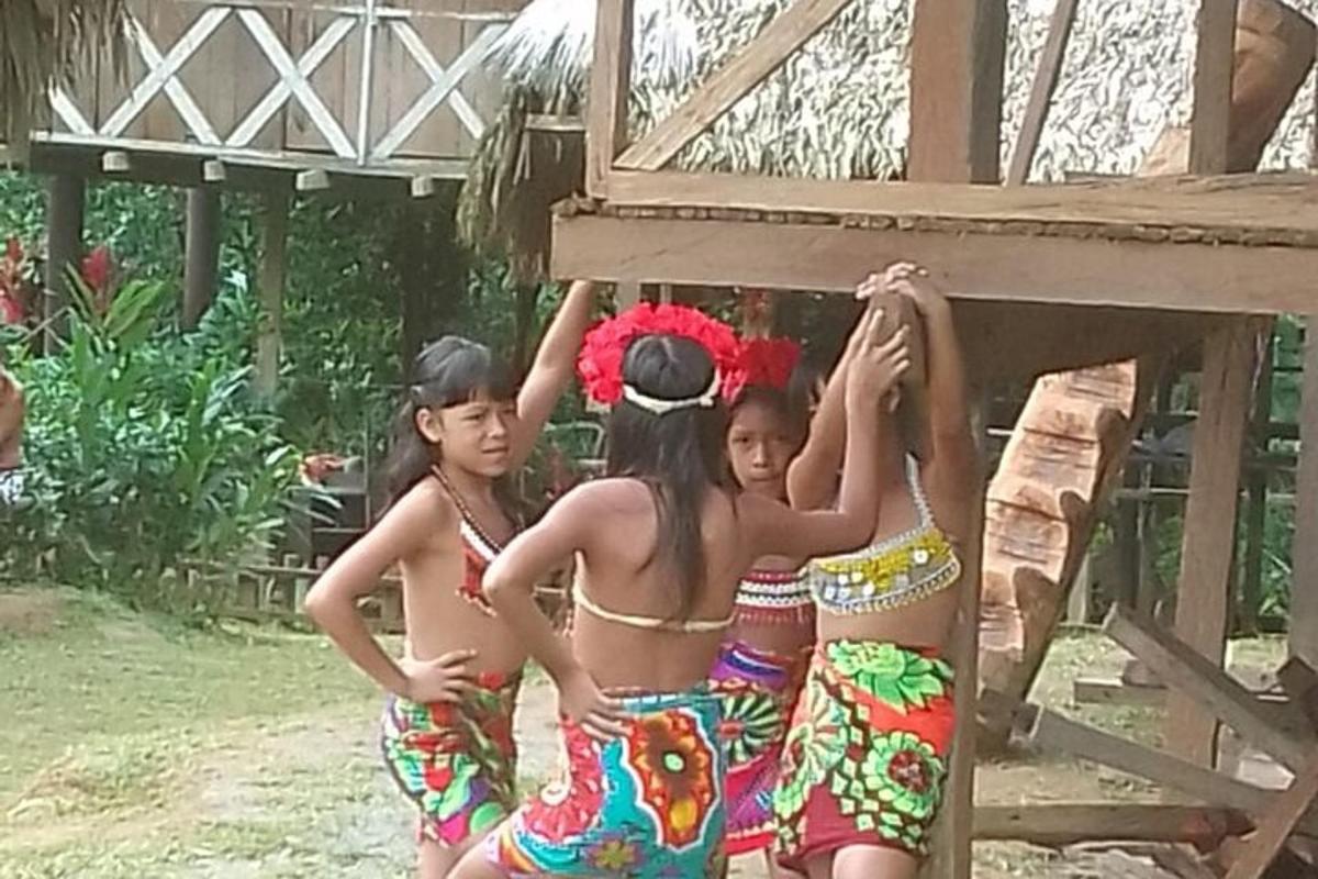 Un grupo de chicas en traje de baño de pie debajo de un edificio.