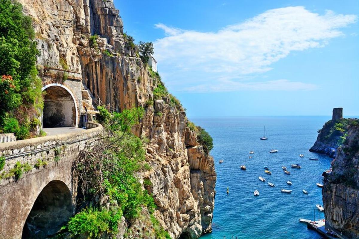 uma ponte em um penhasco sobre a água com barcos