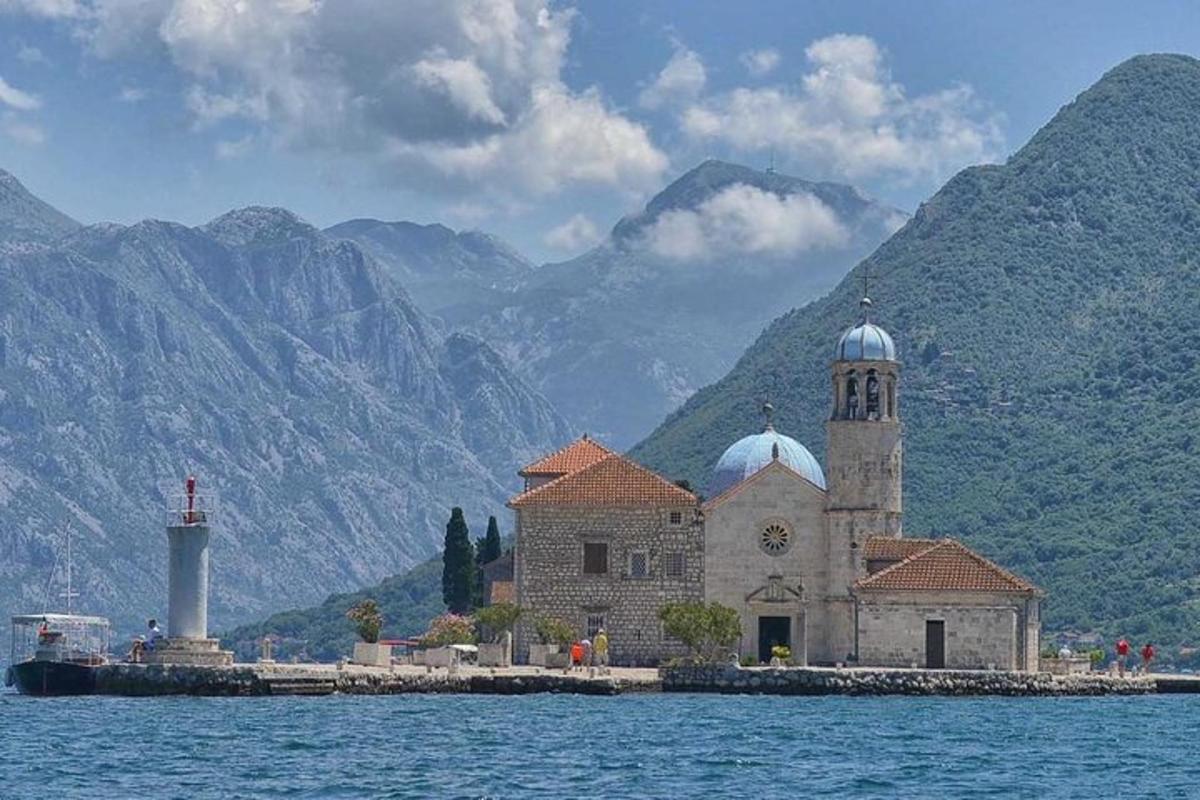 una chiesa su un'isola nell'acqua con le montagne