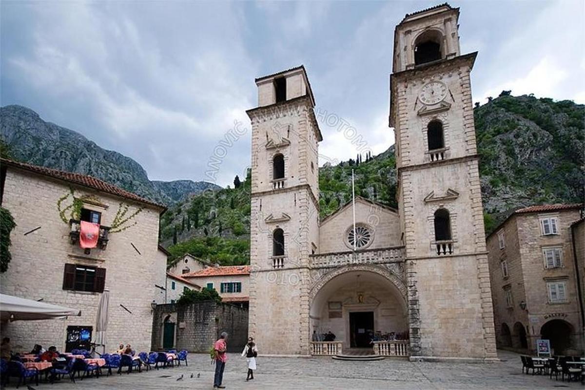 una chiesa con due torri con persone in piedi di fronte ad essa
