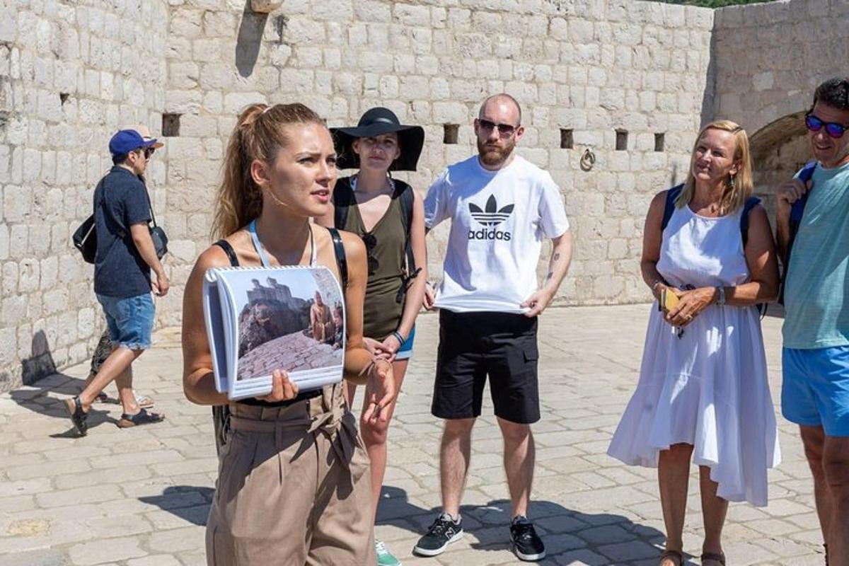 skupina lidí stojící kolem ženy držící obrázek