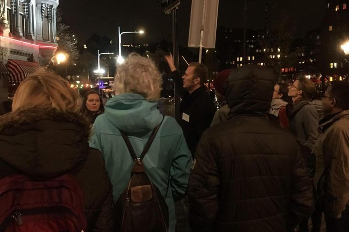 uma multidão de pessoas caminhando pela rua à noite