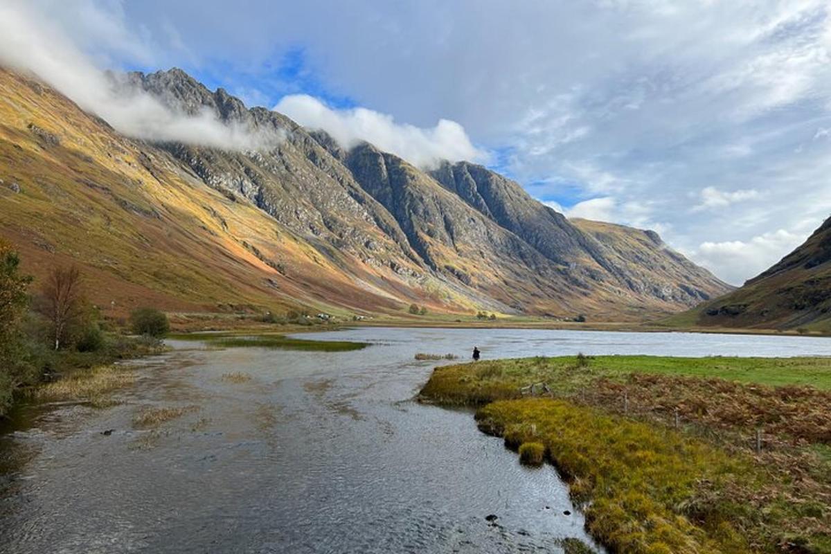a river in a valley with mountains in the background