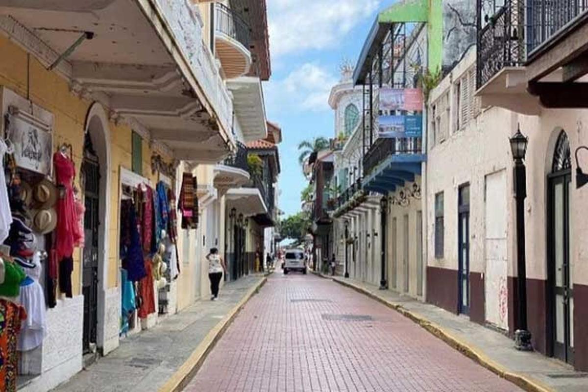 a woman walking down a street next to buildings