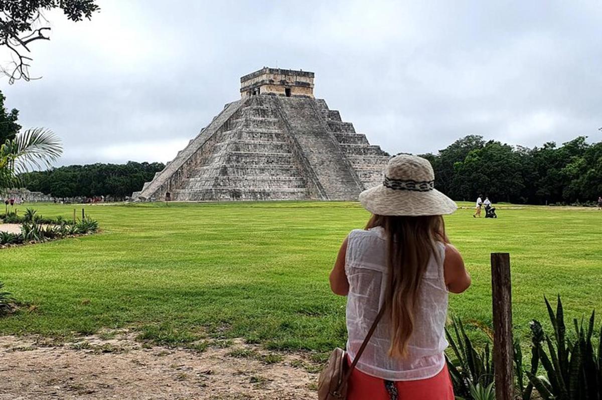 uma jovem em pé em frente à pirâmide