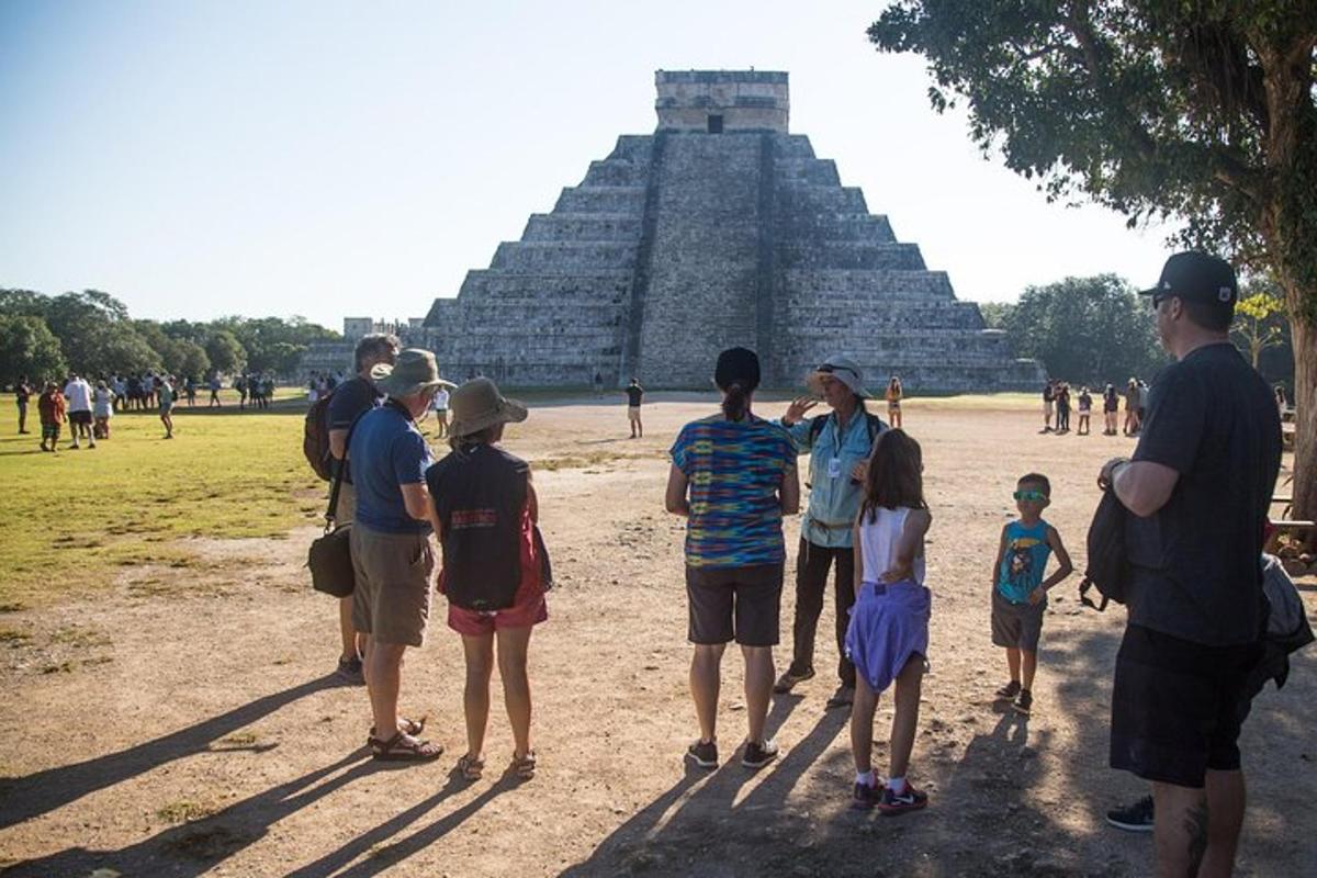 um grupo de pessoas em pé em frente a uma pirâmide