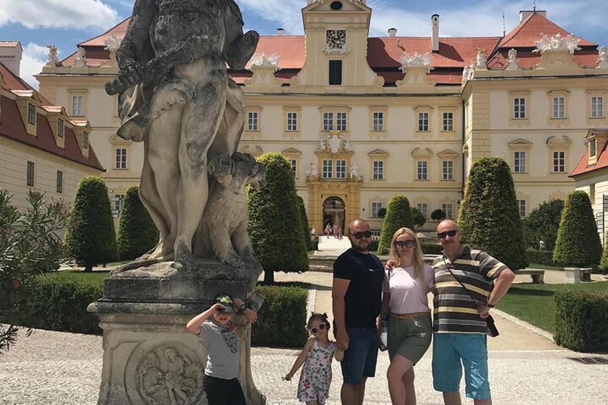 una famiglia in piedi davanti a una statua di fronte a un edificio