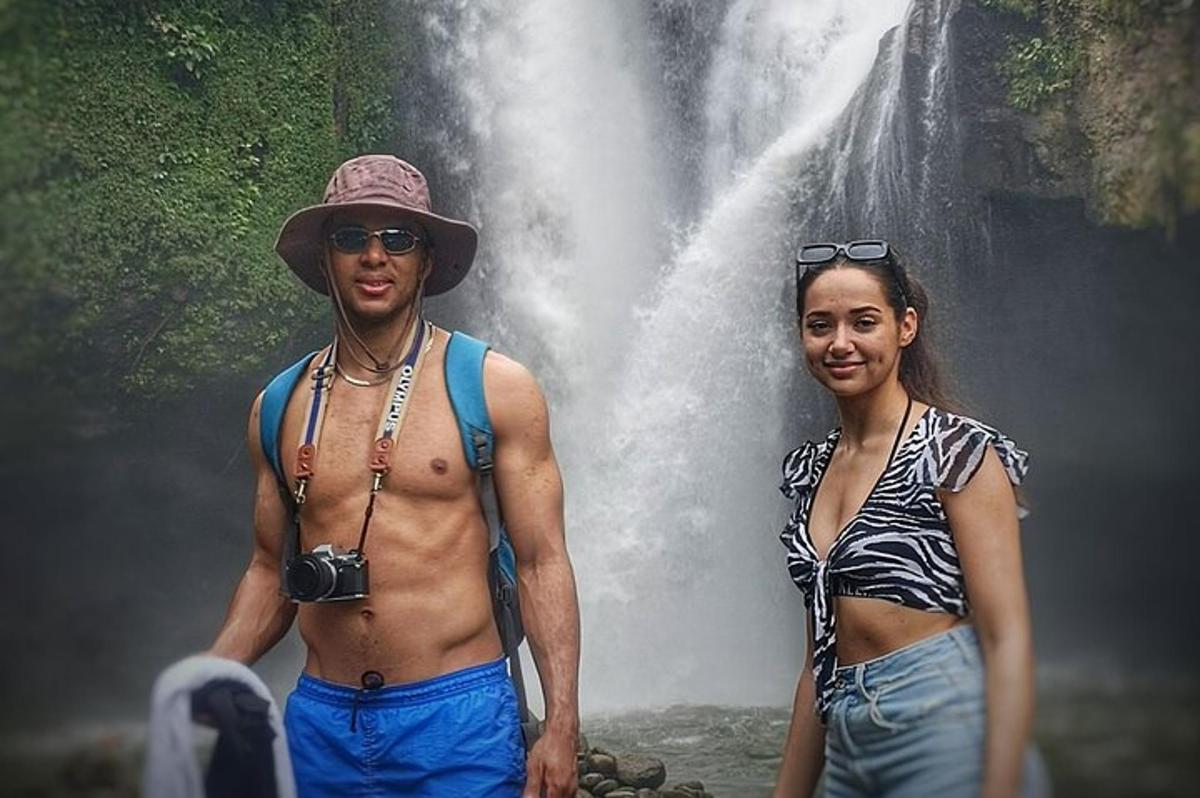 un home i una dona drets davant d'una cascada
