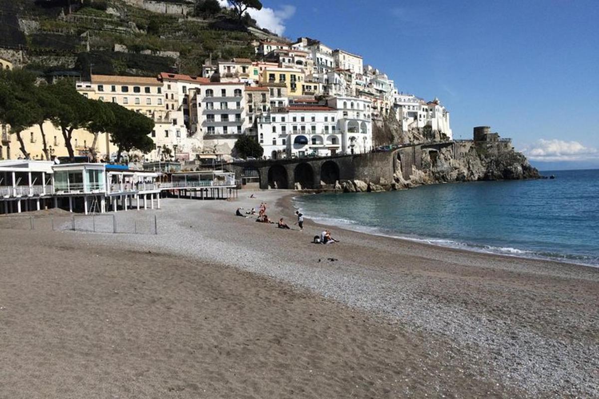 una spiaggia con un gruppo di persone sedute sulla sabbia