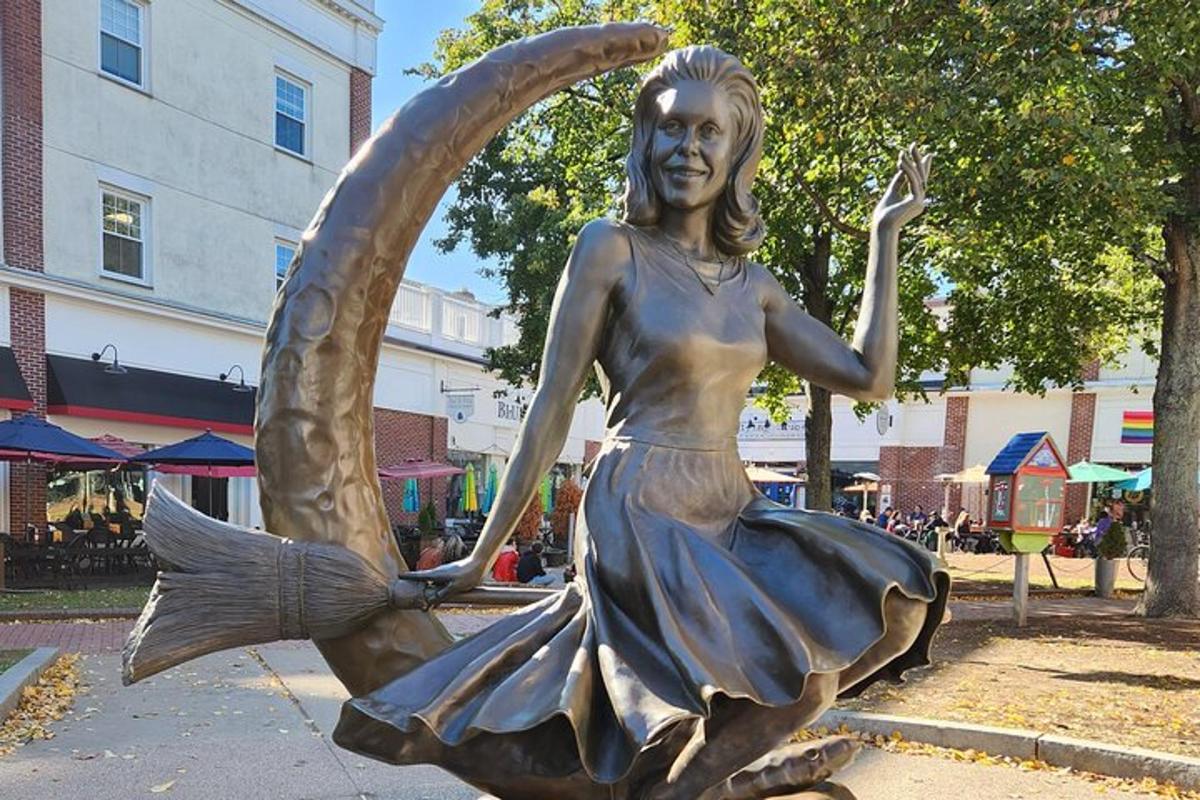 een bronzen beeld van een vrouw die een paraplu vasthoudt