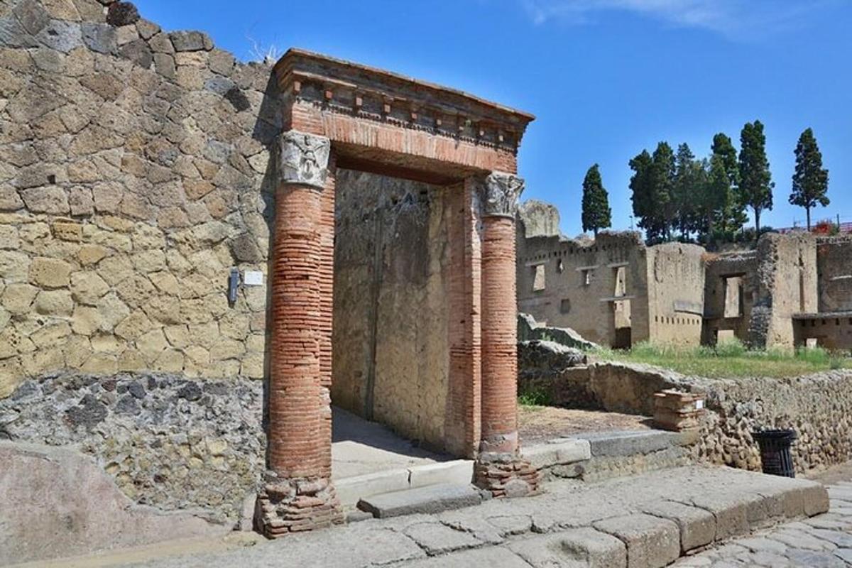 un antico edificio con due colonne di mattoni accanto a un muro