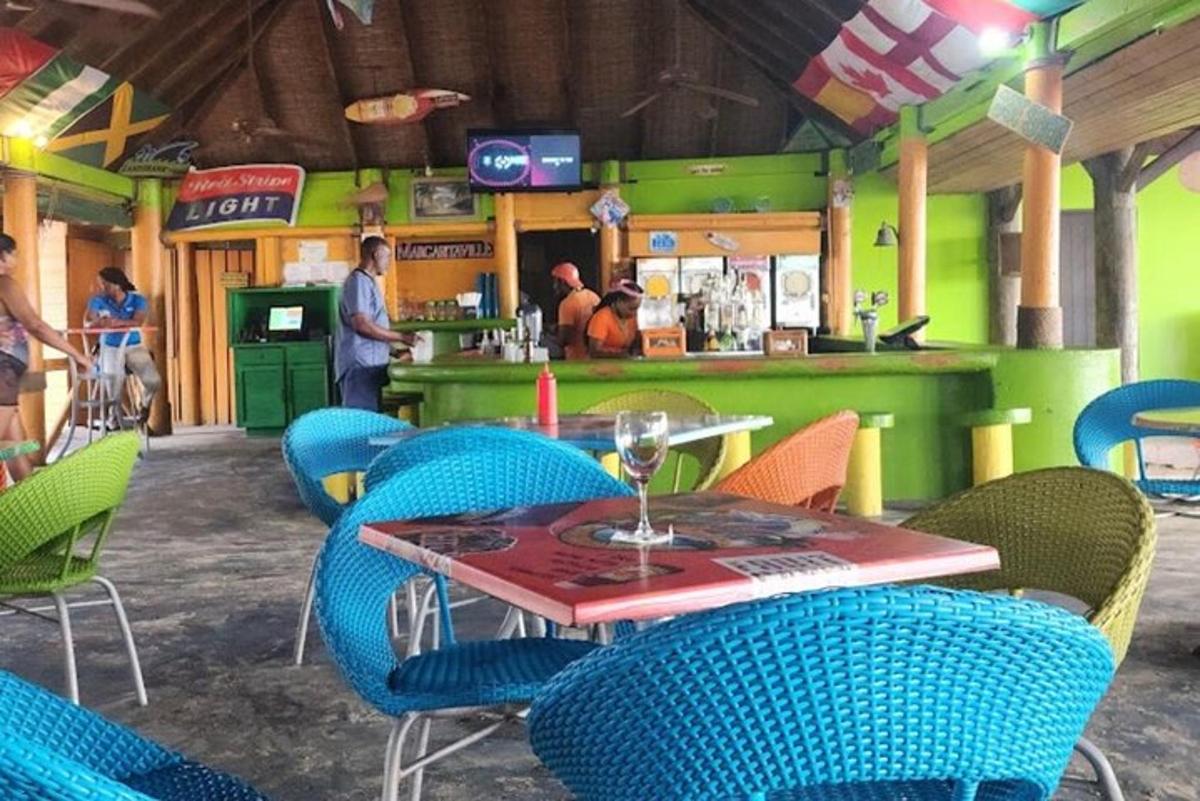 restaurace s modrými židlemi a stolem se sklenicí vína