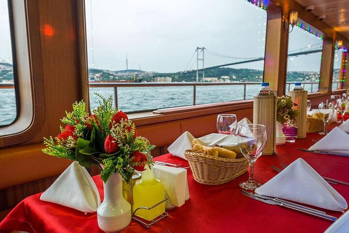 a table with a red table cloth and flowers on a boat