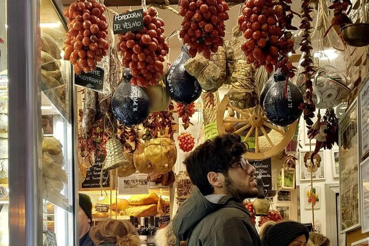 seorang lelaki berdiri di sebuah kedai dengan sekumpulan buah-buahan