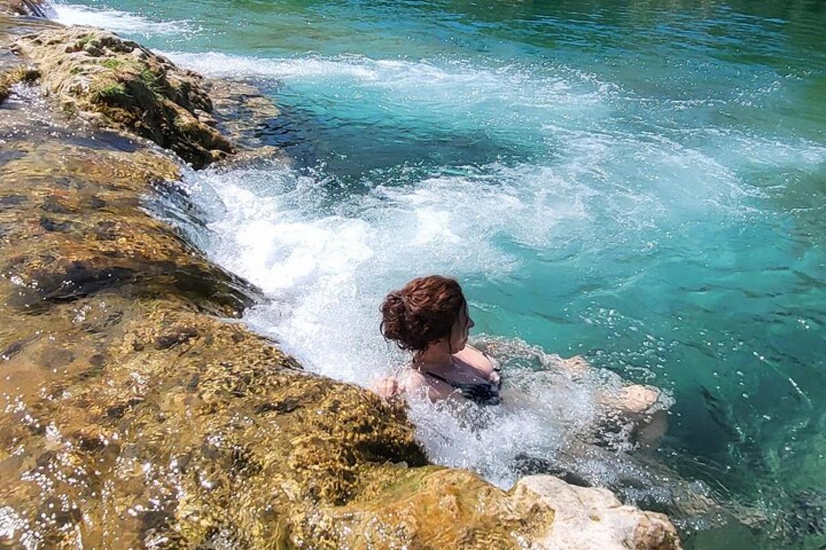 жена је у води поред неких стена