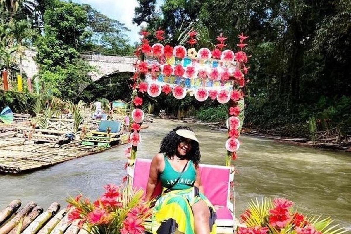 a woman sitting on a pink chair next to a river