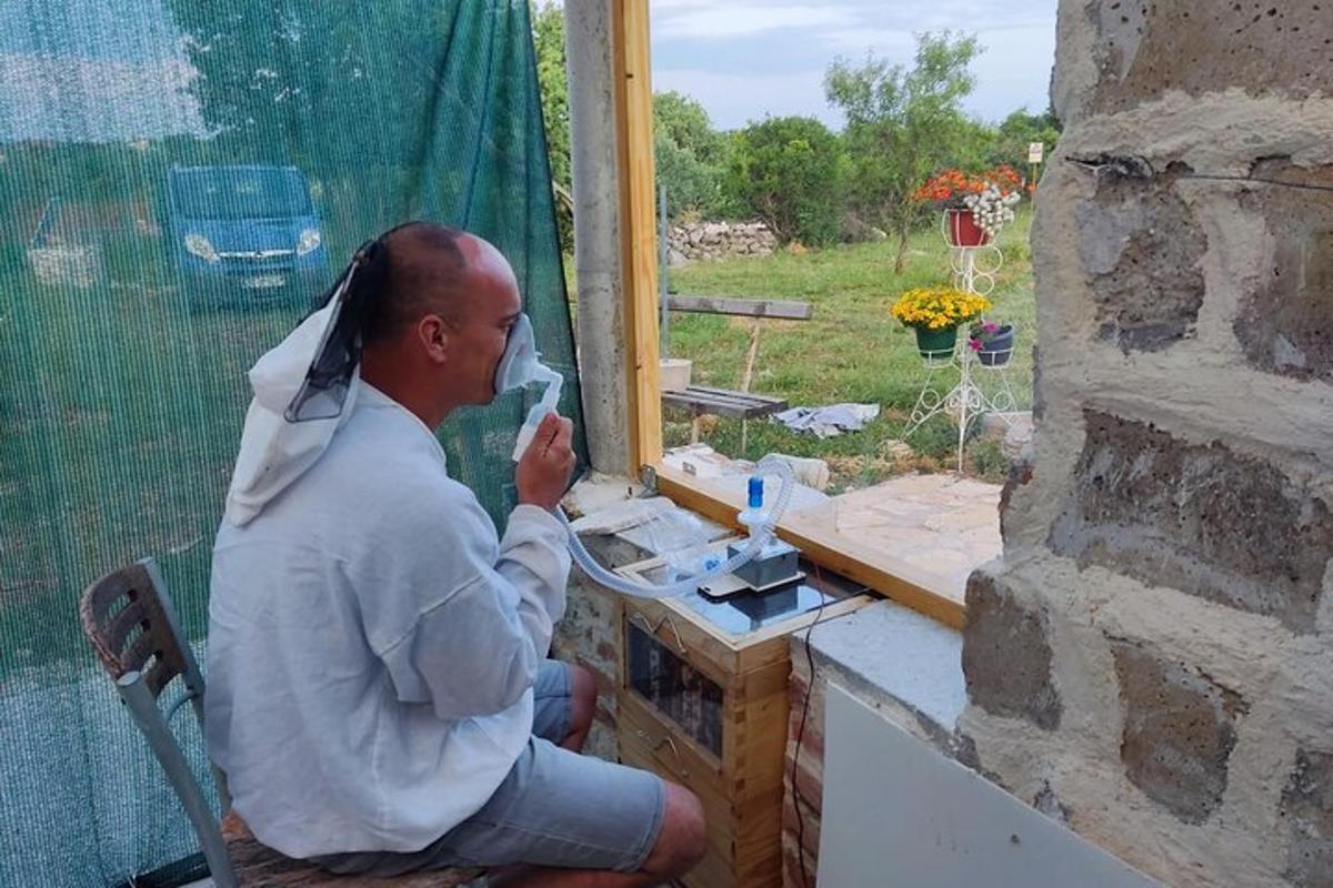 mies istuu tuolissa ikkunan edessä
