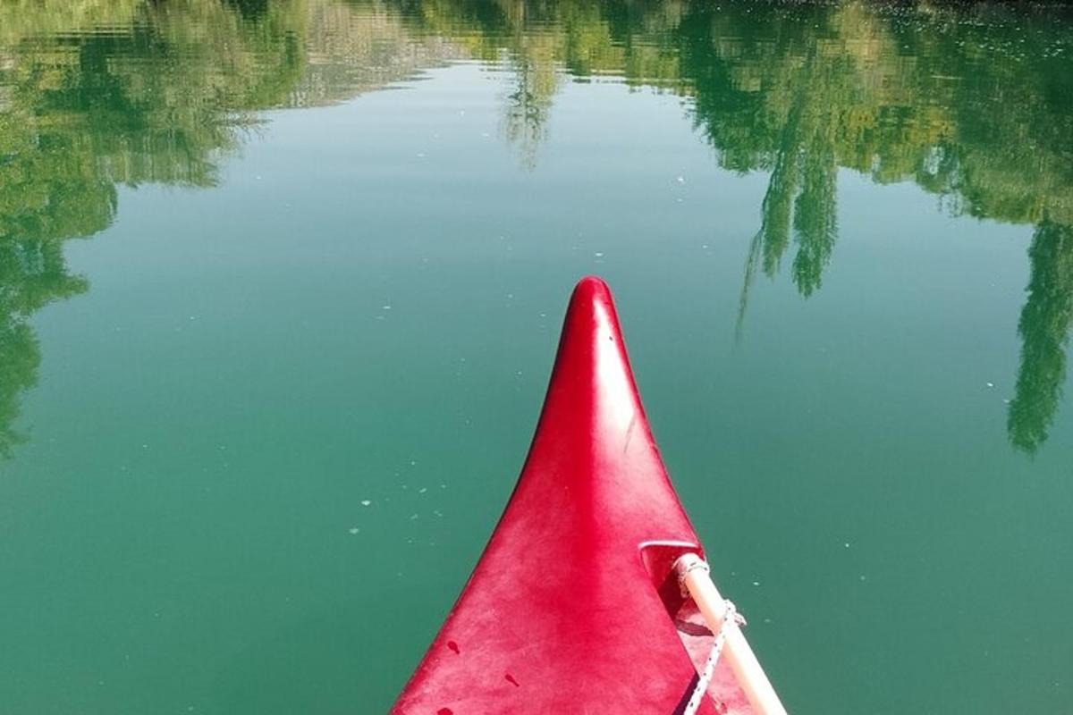 црвени кајак у води са одразом у води
