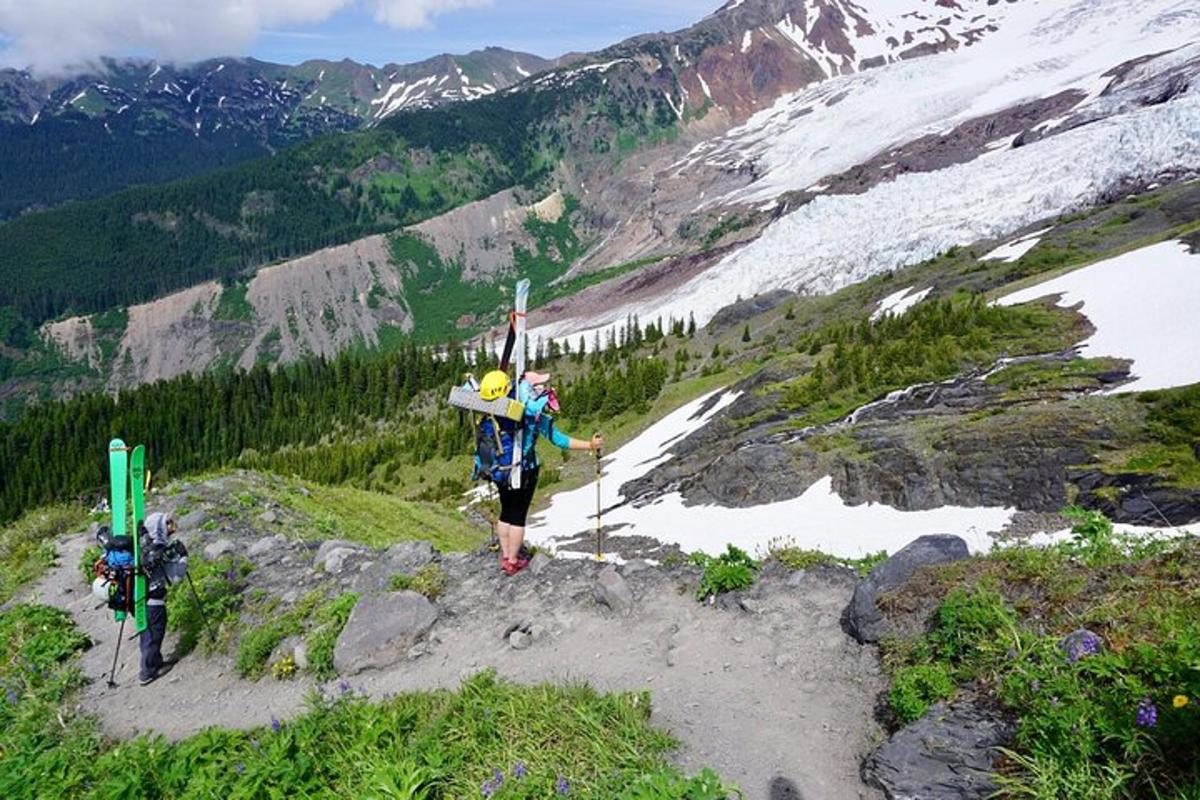 una persona in piedi sulla cima di una montagna con gli sci