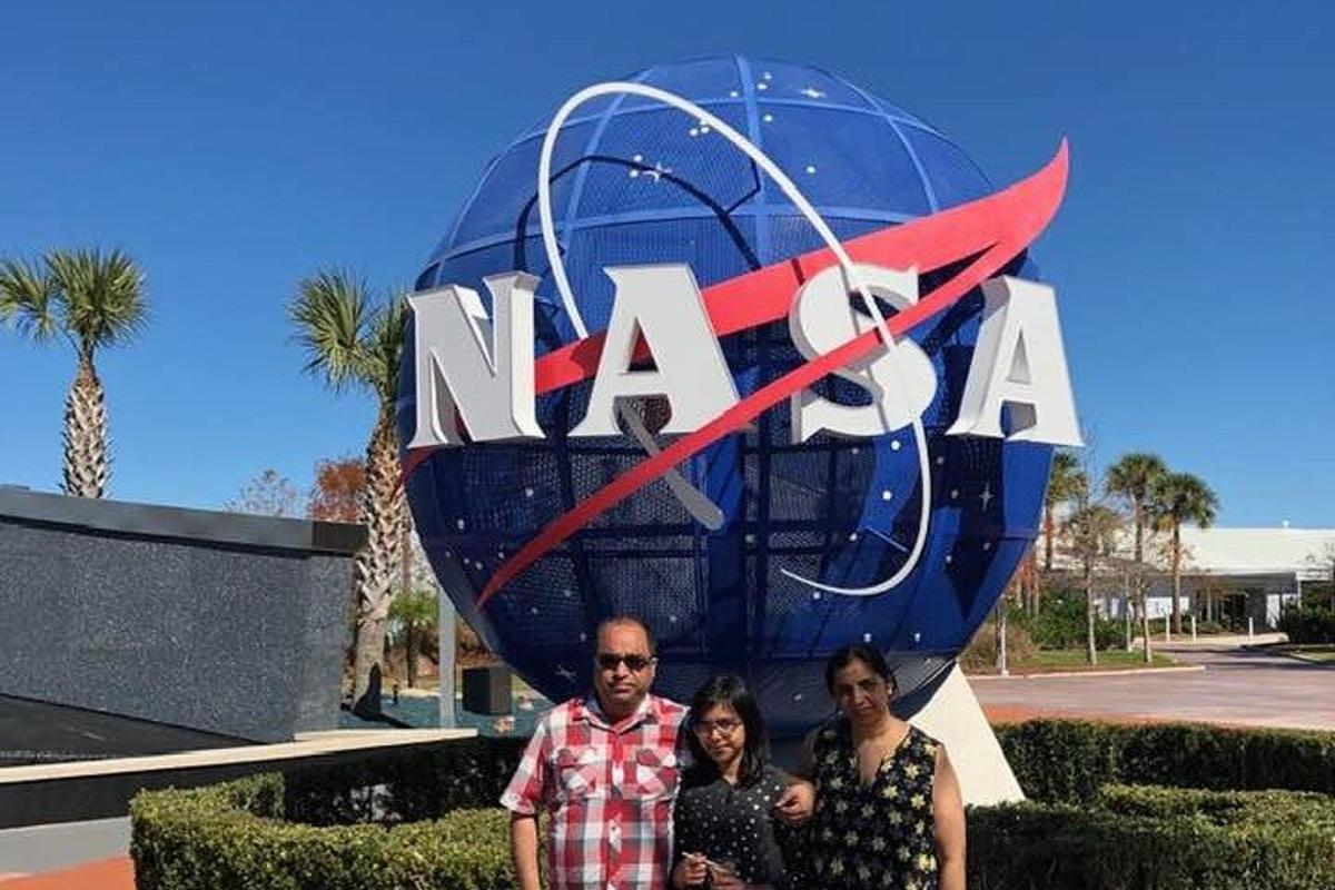 a man and two women standing in front of a sign