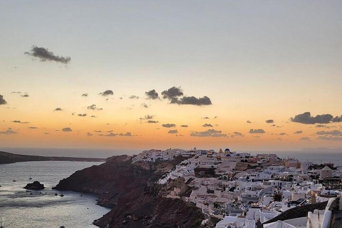 a group of white buildings on a hill next to the ocean